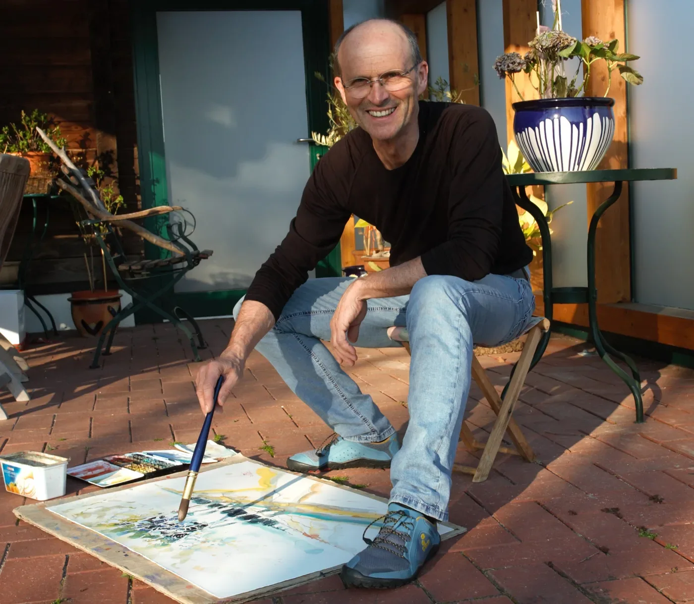 Franz Reitinger beim Malen mit Aquarellfarben auf der Terrasse